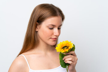 Naklejka premium Young caucasian woman isolated on white background holding a sunflower. Close up portrait