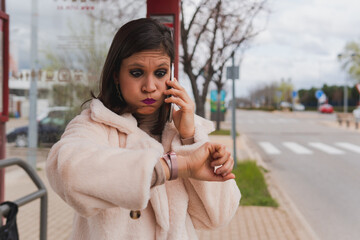 Woman with a desperate face waiting for public transport at the bus stop. Close shot of a young...