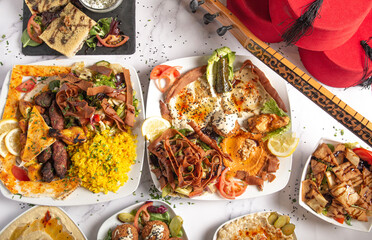 Top view of a variety of Middle Eastern and Arabic food dishes on a white background.