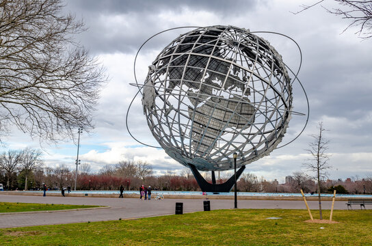 Unisphere at Flushing-Meadows-Park with meadow and people standing in front, Queens, New York City during overcast winter day, horizontal