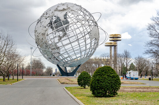 Unisphere with New York State Pavilion Observation Towers at Flushing-Meadows-Park, way and plants in front, Queens, New York City during overcast winter day, horizontal