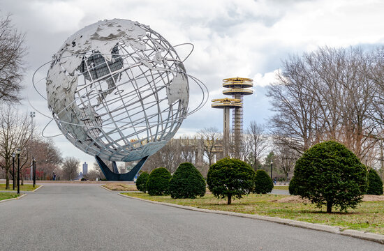 Unisphere with New York State Pavilion Observation Towers at Flushing-Meadows-Park, way and plants in front, low angle view, Queens, New York City during overcast winter day, horizontal