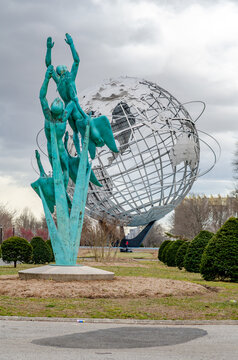 Turquoise Memorial Statue with men flying to the sky in front of Unisphere, Queens, New York City during overcast winter day, vertical