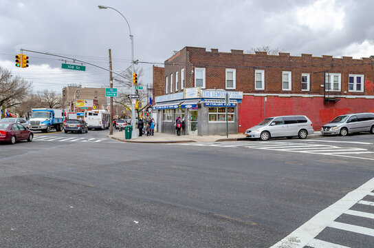 The Lemon Ice King of Corona, Ice Cream Retail Store wide angle, with traffic and people, Queens, New York City during overcast winter day, horizontal