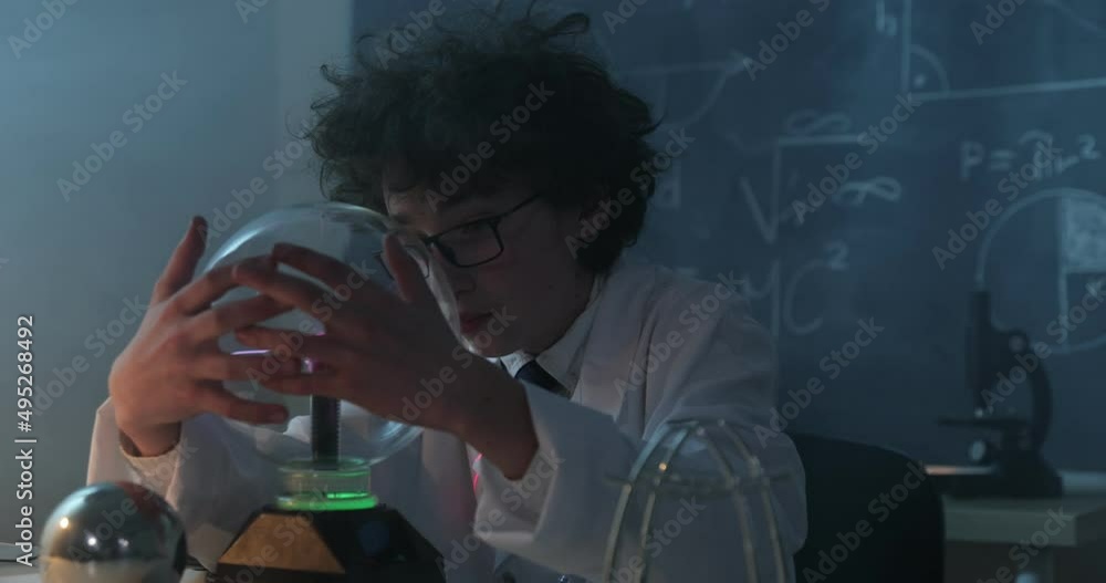 Wall mural schoolboy experimenting in physics class. young student doing physics experiment in the classroom.