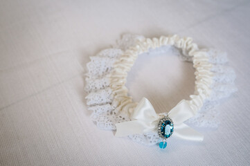 Woman's garter on a white background. Bride accessories. Stylish blue wedding.