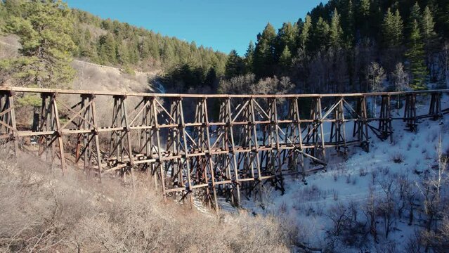 Drone view of an old wooden bridge with railroad tracks