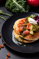 Pouring sose on pancakes. pancakes with salmon and pesto sose . Tasty breakfast food