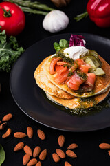Pouring sose on pancakes. pancakes with salmon and pesto sose . Tasty breakfast food