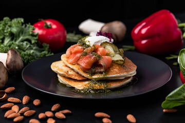 Pouring sose on pancakes. pancakes with salmon and pesto sose . Tasty breakfast food