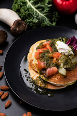 Pouring sose on pancakes. pancakes with salmon and pesto sose . Tasty breakfast food