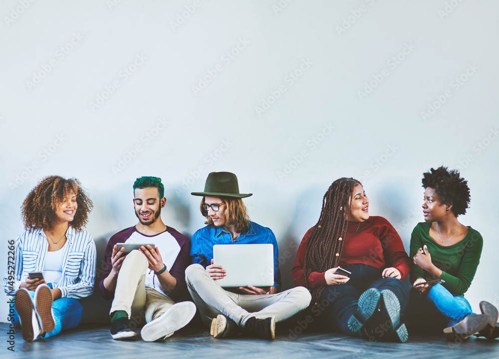 Aufkleber The most tech savvy generation there is. Studio shot of a group of young people sitting on the floor and using wireless technology.