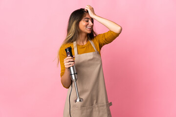 Young chef woman using hand blender isolated on pink background has realized something and intending the solution