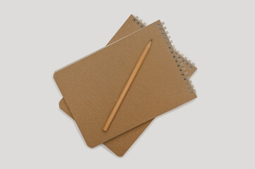 Notepad with a simple pencil on a gray background. Minimalistic layout for design.