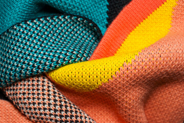 A pile of multi-colored knitted fabrics