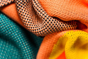 A pile of multi-colored knitted fabrics