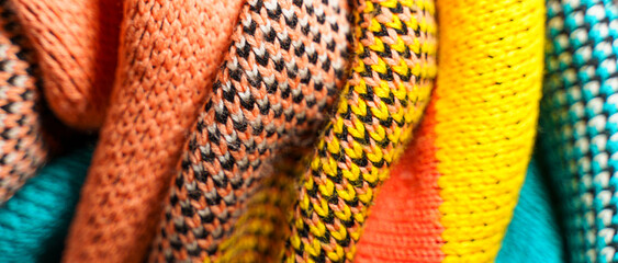 A pile of multi-colored knitted fabrics