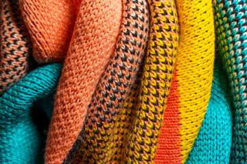 A pile of multi-colored knitted fabrics
