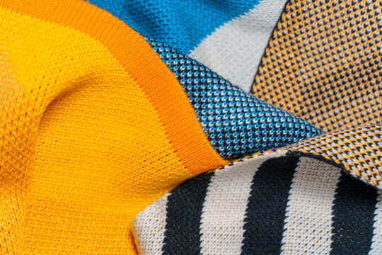 A pile of multi-colored knitted fabrics