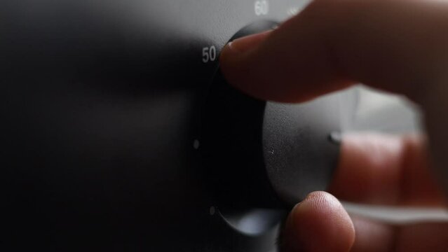 The girl's hand is turning the thermostat button
of the combi boiler