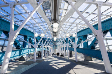 Interior of pedestrian bridge with sophisticated metal structures in contrast light, Moscow, Russia