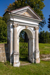 Fototapeta na wymiar Classicist gate at the entrance to a country cemetery, Czechia