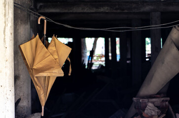 Old umbrella hanging on a rope in the basement of a building, Thailand.