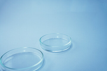 Empty glass plate petri.Petri dish for biological research.Isolated on blue background. Laboratory tests and research.Chemistry science or medical biology experiment.Growing colonies in a petri dish