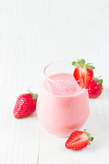 A glass of fresh strawberry smoothie on a white background. Summer drink shake, milkshake and refreshment organic concept.