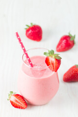 A glass of fresh strawberry smoothie on a white background. Summer drink shake, milkshake and refreshment organic concept.