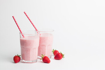 A glass of fresh strawberry smoothie on a white background. Summer drink shake, milkshake and refreshment organic concept.