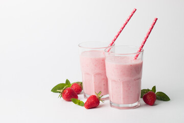A glass of fresh strawberry smoothie on a white background. Summer drink shake, milkshake and refreshment organic concept.