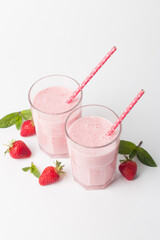 A glass of fresh strawberry smoothie on a white background. Summer drink shake, milkshake and refreshment organic concept.
