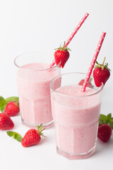 A glass of fresh strawberry smoothie on a white background. Summer drink shake, milkshake and refreshment organic concept.