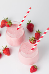 A glass of fresh strawberry smoothie on a white background. Summer drink shake, milkshake and refreshment organic concept.