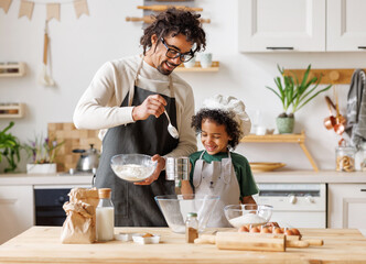 Black man and son cooking together in kitchen