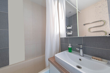 interior of a small compact bathroom with a mirror sink and wooden countertop