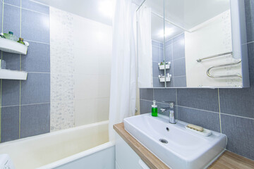interior of a small compact bathroom with a mirror sink and wooden countertop