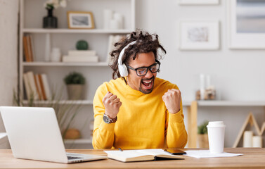 Fototapeta na wymiar Overjoyed african american man looking at laptop screen feeling excited after receiving job offer