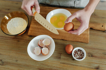 Cooking in progress. Eggs, flour, salt on the table, cutting board and knife. Dough Ingredients. View from above