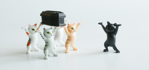 Funny toy kittens carry a black coffin. The concept of a funeral procession dancing with a coffin....