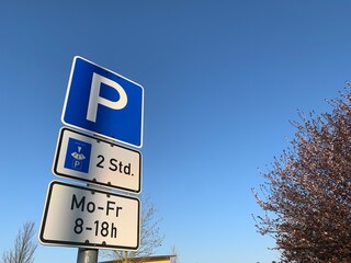 Parkplatz Strassenschild mit Zeitangabe auf blauem Himmel