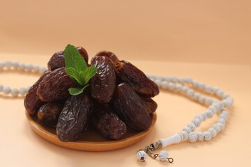 Fresh date fruits and white prayer beads, ramadhan concept idea. Sitting view. Vibrant color date fruit prepared for iftar.