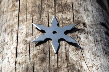 Shuriken (throwing star), traditional japanese ninja cold weapon stuck in wooden background