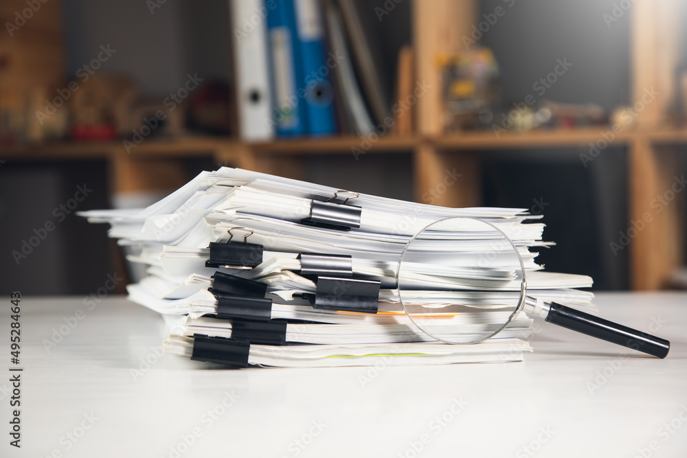 Aufkleber stack of report paper documents with magnifying glass