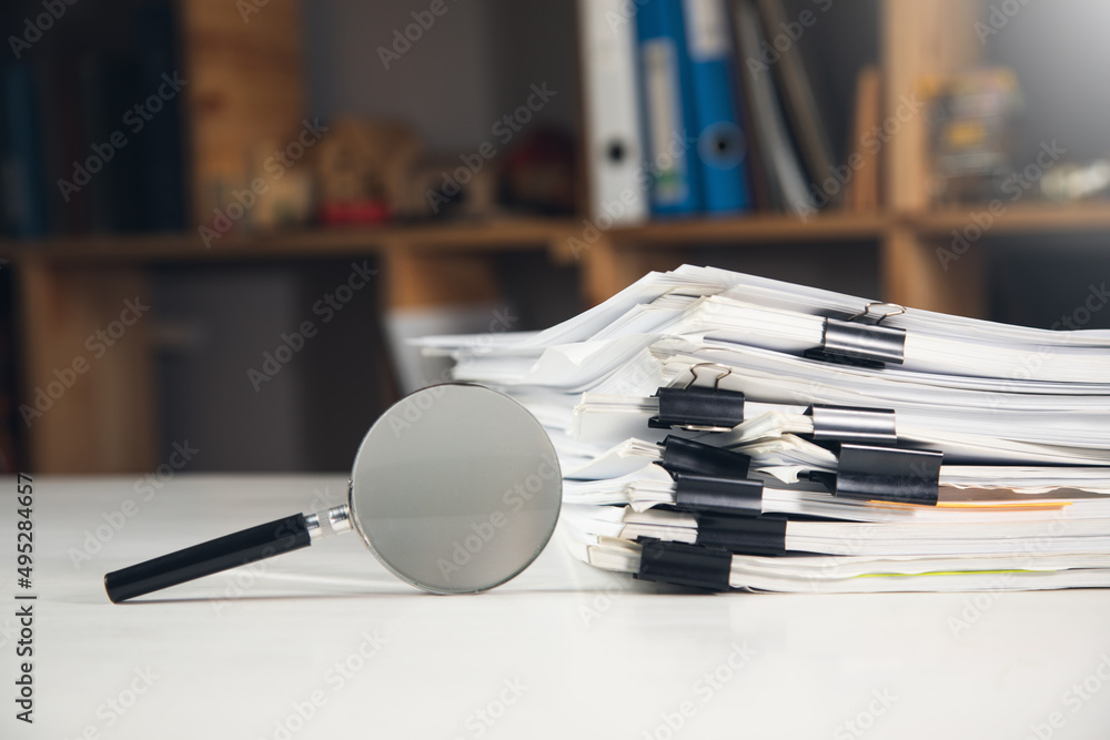 Poster stack of report paper documents with magnifying glass