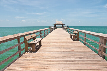 Obraz premium front view of a deserted, wood pier, extending one hundred yards, into the gulf of Mexico, on a sunny afternoon