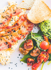 Scrambled eggs with bacon avocado and orange juice