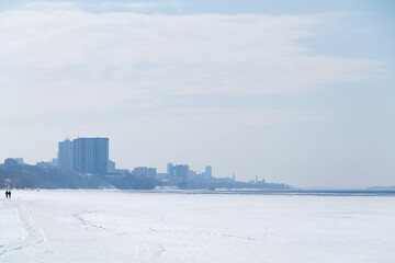 city in the snow in winter. landscape of blue river and sky with sunlight and snow.