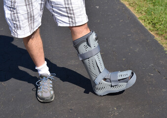 A man wearing an orthopedic air boot after breaking a foot bone.